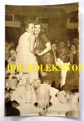 HÜLYA KOÇYİĞİT ve KARDEŞİ NİLÜFER KOÇYİĞİT'İN ORİJİNAL 2'Lİ FOTOĞRAF SETİ - 18 x 12 cm EBADINDA - NİLÜFER KOÇYİĞİT, DOĞUM GÜNÜ PARTİSİNDE ABLASI HÜLYA KOÇYİĞİT'LE SARILIP BİRLİKTE PASTA KESTİĞİ ANLARDA ÇEKİLMİŞ 2 FARKLI KARE. SELİM SOYDAN DA KADRAJDA YER ALMAKTADIR