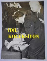 YEŞİLÇAM'IN UNUTULMAZ OYUNCUSU LEYLA SAYAR'IN ORİJİNAL BÜYÜK BOY 4'LÜ FOTOĞRAF SETİ - 24 x 18 cm,  22,5 x 18 cm ve 21 x14 cm ve EBADINDA - LEYLA SAYAR, FENALAŞTIĞI ANLARDA KENDİSİNE İLKYADIM MÜDAHALESİ YAPILIRKEN ÇEKİLMİŞ 4 FARKLI KARE. (RIZA PAKYÜZ)