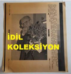 ERDAL İNÖNÜ'NÜN ORİJİNAL AJANS-BASIN FOTOĞRAFI (KAĞIT BASKI) - 21 x 19 cm EBADINDA - ERDAL İNÖNÜ, 1 MAYIS NEDENİYLE SHP GENEL MERKEZİNDE DÜZENLENEN TÖREN SONRASINDA ELİNDE ÇİÇEKLERİ TUTARKEN ÇEKİLMİŞ BİR KARE. 1990. SELFET GÜNER
