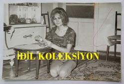 YEŞİLÇAM OYUNCUSU ve 1969 TÜRKİYE GÜZELİ ZUHAL AKTAN'IN ORİJİNAL 2'Lİ FOTOĞRAF SETİ - 18 x 12 cm EBADINDA - ZUHAL AKTAN, EVİNDE SEHPANIN ÜZRİNDE BİR ŞEYLER YERKEN ÇEKİLMİŞ 2 FARKLI KARE