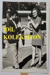 YEŞİLÇAM OYUNCUSU ve 1969 TÜRKİYE GÜZELİ ZUHAL AKTAN'IN ORİJİNAL 2'Lİ FOTOĞRAF SETİ - 18 x 12 cm EBADINDA - ZUHAL AKTAN, BİR PARKTAKİ SEYYAR ÇEKİLİŞTE SİGARA KAZANIRKEN ÇEKİLMİŞ 2 FARKLI KARE