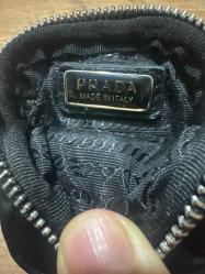 Prada tarzı mini nylon pouch (aksesuar çantası). Anahtarlık, AirPods, bozuk para veya küçük eşyalar için ideal kullanımlı kompakt bir modeldir. Naylon gövde + deri kayış  Metal fermuar İç kısmında Prada yazılı metal plaka Bel çantasına, sırt çantasına veya kemere takılabilir Temiz durumdadır, yırtık/defosu yoktur Küçük ve pratik bir yan aksesuar isteyenler için uygundur. 2 Adet tertemiz