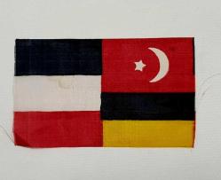 1. DÜNYA SAVAŞI İTTİFAK İPEK BAYRAK ALMANYA, AVUSTURYA MACARİSTAN İMPARATORLUĞU VE OSMANLI İMPARATORLUĞU BAYRAKLARININ BULUNDUĞU İTTİFAK BAYRAĞI. 14 x 8,5 cm.