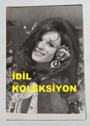 YEŞİLÇAM'IN YILDIZI HÜLYA KOÇYİĞİT'İN ORİJİNAL FOTOĞRAFI  - 18 x 12 cm EBADINDA - HÜLYA KOÇYİĞİT KULAĞINDAKİ ÇİÇEKLE KADRAJA GÜLÜMSERKEN ÇEKİLMİŞ GÜZEL BİR KARE