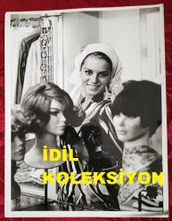 YEŞİLÇAM'IN YILDIZI HÜLYA KOÇYİĞİT'İN ORİJİNAL BÜYÜK BOY FOTOĞRAFI  - 24 x 18 cm EBADINDA - HÜLYA KOÇYİĞİT BEYAZ BAŞÖRTÜSÜ TAKIP PERUKLARIN YANINDA GÜLÜMSEYEREK KADRAJA POZ VERİRKEN ÇEKİLMİŞ BİR KARE