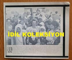YEŞİLÇAM'IN YILDIZI HÜLYA KOÇYİĞİT'İN ORİJİNAL AJANS-BASIN FOTOĞRAFI (KAĞIT BASKI, HABER METİNLİ) - 22 x 19 cm EBADINDA - HÜLYA KOÇYİĞİT, ZİYARETE GİTTİĞİ KÖYDE KADINLARIN ARASINDA POZ VERİRKEN