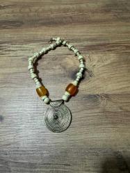Vintage Etnik Kolye   Kemik Boncuk & Pirinç Uç El yapımı görünüme sahip, kemik boncuklu etnik kolye. Kehribar tonlarında detaylar ve spiral desenli pirinç alaşım uç ile tamamlanmıştır. Bohem ve etnik tarz sevenler için karakterli bir parça. Genel durumu iyi, kullanıma uygundur.