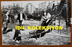 YEŞİLÇAM'IN YILDIZI HÜLYA KOÇYİĞİT'İN ORİJİNAL FOTOĞRAFI  - 18 x 12 cm EBADINDA - HÜLYA KOÇYİĞİT, KIZI GÜLŞAH ALKOÇLAR'I PARKTA KAYKAYDAN KAYDIRIRKEN ÇEKİLMİŞ BİR KARE