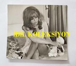 YEŞİLÇAM OYUNCUSU AYNUR AYDAN'IN ORİJİNAL FOTOĞRAFI - 11,5 x 10,5 cm EBADINDA - AYNUR AYDAN  YATAĞINDA OYUNCAK BEBEKLERİYLE İLGİLENİRKEN ÇEKİLMİŞ BİR KARE