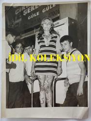 YEŞİLÇAM OYUNCUSU AYNUR AYDAN'IN BÜYÜK BOY ORİJİNAL FOTOĞRAFI - 24 x 18 cm EBADINDA - AYNUR AYDAN, ÇİÇEK DESENLERİYLE BOYANMIŞ OLARAK ÇOCUKLARIN YANINDA POZ VERİRKEN ÇEKİLMİŞ BİR KARE