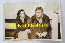 YEŞİLÇAM'IN UNUTULMAZ OYUNCUSU TAMER YİĞİT'İN ORİJİNAL FOTOĞRAFI - 18 x 12 cm EBADINDA - TAMER YİĞİT EŞİ RUKİYE İLE YAN YANA OTURURKEN ÇEKİLMİŞ BİR KARE. OCAK 1982