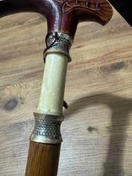 Gümüş Damgalı,Fil dişi ve Ahşap El İşçiliği Sedef işlemeli Özel yapım Baston 1992 Özel Yapım - 950 Ayar Gümüş bilezikler ara kısmında Fil dişiyle yapılmış Koleksiyonluk Baston Kaliteli ahşap gövde ve oymalı sap. Temiz, bakımlı ve koleksiyonluk kondisyonda. Hem kullanım hem de dekorasyon için uygun, nadir bir parçadır. Boy 87 cm