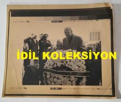 TÜRKİYE CUMHURİYETİ 2. CUMHURBAŞKANI İSMET İNÖNÜ'NÜN AİLESİNİN AJANS-BASIN FOTOĞRAFI (KAĞIT BASKI) - 21 x 19 cm EBADINDA - İSMET İNÖNÜ'YÜ ANMA TÖRENİNDE OĞLU ERDAL İNÖNÜ ÇELENK BAŞINDA DURURKEN ÇEKİLMİŞ BİR KARE