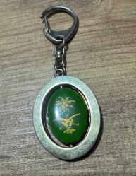 Vintage Suudi Arabistan Armalı & Mescid-i Nebevi Görselli Anahtarlık Metal gövde ve dönen iç parça. Bir tarafı palmiye ve kılıçlı ülke arması, diğer tarafı Yeşil Kubbe işlemelidir. Mekanizması sorunsuz çalışmaktadır. Zamana bağlı doğal eskitme almış,