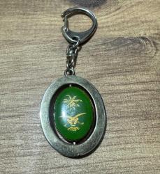 Vintage Suudi Arabistan Armalı & Mescid-i Nebevi Görselli Anahtarlık Metal gövde ve dönen iç parça. Bir tarafı palmiye ve kılıçlı ülke arması, diğer tarafı Yeşil Kubbe işlemelidir. Mekanizması sorunsuz çalışmaktadır. Zamana bağlı doğal eskitme almış,