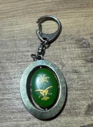 Vintage Suudi Arabistan Armalı & Mescid-i Nebevi Görselli Anahtarlık Metal gövde ve dönen iç parça. Bir tarafı palmiye ve kılıçlı ülke arması, diğer tarafı Yeşil Kubbe işlemelidir. Mekanizması sorunsuz çalışmaktadır. Zamana bağlı doğal eskitme almış,