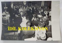 KLASİK TÜRK MÜZİĞİ SANATÇISI ve BESTECİ MÜNİR NURETTİN SELÇUK'UN ORİJİNAL FOTOĞRAFI - 18 x 12 cm EBADINDA - MÜNİR NURETTİN SELÇUK, PARİS CAMİİ'NDEKİ KONSERDE DİNLEYİCİLERİ SELAMLADIĞI SIRADA TOPLULUK TARAFINDAN ALKIŞLANIRKEN ÇEKİLMİŞ BİR KARE