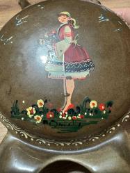 Koleksiyonluk Nostaljik Seramik Matara Üzerinde el işçiliğiyle yapılmış yöresel kadın figürü ve çiçek motifleri bulunan, sanatçı imzalı nadir bir parçadır. Üçlü ağız yapısı ve kendinden ayaklı dairesel formuyla özgün bir tasarıma sahiptir. Koleksiyonluk temizliktedir; çatlak, kırık veya boya atması yoktur. • Kullanım: Vitrin ve masaüstü dekorasyonu için şık bir retro objedir. Koleksiyoncular ve nostalji sevenler için kaçırılmayacak bir parça