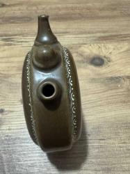 Koleksiyonluk Nostaljik Seramik Matara Üzerinde el işçiliğiyle yapılmış yöresel kadın figürü ve çiçek motifleri bulunan, sanatçı imzalı nadir bir parçadır. Üçlü ağız yapısı ve kendinden ayaklı dairesel formuyla özgün bir tasarıma sahiptir. Koleksiyonluk temizliktedir; çatlak, kırık veya boya atması yoktur. • Kullanım: Vitrin ve masaüstü dekorasyonu için şık bir retro objedir. Koleksiyoncular ve nostalji sevenler için kaçırılmayacak bir parça