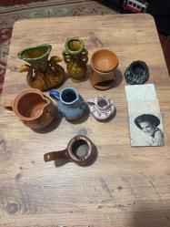 Nostaljik Dekoratif Obje ve Seramik Lotu Evinize otantik bir hava katacak, vintage tarzda seramik ve dekoratif ürünler. Hepsi temiz durumdadır, kırık veya çatlak bulunmamaktadır. İster koleksiyonluk ister dekoratif kullanım için uygundur. Çift Kuğulu Büyük Vazo: Gösterişli, yeşil-hardal tonlarında.  Mavi-Beyaz El Boyaması Sürahi Klasik desenli. • Toprak Yağ Kandili / Buhurdanlık: Doğal dokulu. Elvis Presley Baskılı Taş Bardak Altlığı: (3 adetlik set). Minyatür Vazolar ve Kül Tablası Farklı form ve renklerde.