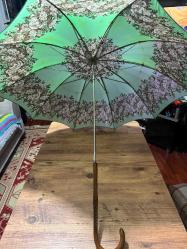 Vintage Antika Ahşap Saplı Şemsiye Koleksiyonluk Nadir bulunan fıstık yeşili tonunda, nostaljik çiçek desenli kumaş. Zarif el işçiliğiyle oyulmuş, gürgen/meşe görünümlü kıvrımlı gerçek ahşap sap. Yaşına göre çok iyi durumda, mekanizması sorunsuz çalışmaktadır. İster günlük şıklık için, ister dekoratif amaçlı veya fotoğraf çekimlerinde aksesuar olarak kullanılabilir. Eski dönemlerin zarafetini taşıyan, koleksiyon değeri yüksek bir parçadır.