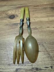 Antika Gümüş İşlemeli Boynuz Servis Takımı Zarafeti ve doğallığı bir arada sunan, koleksiyonluk servis seti (kaşık ve çatal). Özel gün sofralarınıza prestij katacak ya da dekoratif olarak sergilenecek nadide bir parçadır. Tutma yerleri ve uç kısımları doğal boynuz/kemik dokulu özel malzeme. Orta kısımları ince işçilikli, gümüş kaplama kabartma motiflerle bezelidir. Yaşına bağlı hafif bir patina (eskimiş doku) almış olup, herhangi bir kırığı bulunmamaktadır. Vintage/Antika severler için idealdir. Salata servisi veya dekoratif amaçlı uygundur.