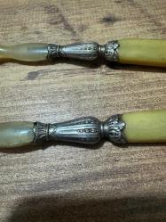 Antika Gümüş İşlemeli Boynuz Servis Takımı Zarafeti ve doğallığı bir arada sunan, koleksiyonluk servis seti (kaşık ve çatal). Özel gün sofralarınıza prestij katacak ya da dekoratif olarak sergilenecek nadide bir parçadır. Tutma yerleri ve uç kısımları doğal boynuz/kemik dokulu özel malzeme. Orta kısımları ince işçilikli, gümüş kaplama kabartma motiflerle bezelidir. Yaşına bağlı hafif bir patina (eskimiş doku) almış olup, herhangi bir kırığı bulunmamaktadır. Vintage/Antika severler için idealdir. Salata servisi veya dekoratif amaçlı uygundur.