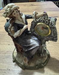 Antika Görünümlü Klasik Kadın Figürlü Masa Saati Zarif kadın figürü ve barok tarzı detaylarla süslenmiş, estetik bir dekoratif objedir. Temiz kullanılmış, vintage bir görünüme sahiptir. Hem saat hem de biblo olarak kullanılabilir. Çalışma masası, konsol üzeri veya kitaplık için mükemmel bir aksesuardır. Şık bir hediye seçeneği olabilir. Poliresin/Döküm benzeri dayanıklı malzeme. Çalışır durumda. 19x 14 cm