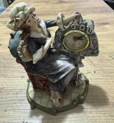 Antika Görünümlü Klasik Kadın Figürlü Masa Saati Zarif kadın figürü ve barok tarzı detaylarla süslenmiş, estetik bir dekoratif objedir. Temiz kullanılmış, vintage bir görünüme sahiptir. Hem saat hem de biblo olarak kullanılabilir. Çalışma masası, konsol üzeri veya kitaplık için mükemmel bir aksesuardır. Şık bir hediye seçeneği olabilir. Poliresin/Döküm benzeri dayanıklı malzeme. Çalışır durumda. 19x 14 cm