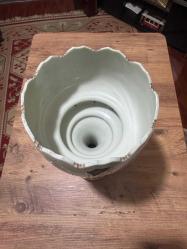 Antika El İşçiliği Kristal Taşlı Opalin Vazo / Obje Evinize klasik bir hava katacak, oldukça zarif ve detaylı bir objedir. Ürün, döneminin estetiğini yansıtan özel süslemelere ve kristal sarkıtlara sahiptir. Gövde üzerinde el işçiliği olduğu anlaşılan altın yaldız ve renkli mine (enamel) işlemeler mevcuttur. Kenarları tırtıklı (scalloped) formdadır. Gövde altından sarkan cam/kristal taşlar ışığı harika yansıtır. Ürünün orijinal ayağı zaman içinde kırıldığı için, görsellerde görülen metal destekli farklı bir ayak ile monte edilmiş. Koleksiyoncular veya evinde nostaljik bir dokunuş arayanlar için kaçırılmayacak şıklıkta bir parçadır.