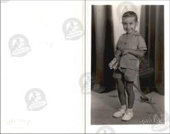 Foto Gün, Mersin, Fotoğraf Stüdyosu, Fotoğraf, 1950’ler: Kısa pantolonlu küçük bir erkek çocuğu, elinde oyuncakla stüdyo fonu önünde ayakta poz veriyor.