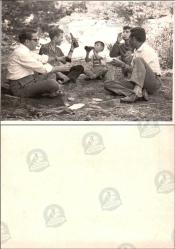 Mesire Alanı, Fotoğraf, 1950’ler: Ağaçlık alanda yere oturmuş beş kişilik grup ve bir çocuk, şişeler ve kâğıtlarla piknik molası.