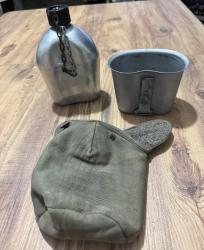 Antika 1953 Orijinal ABD Askeri Matara Seti - Koleksiyonluk & Tam Takım Koleksiyoncular ve outdoor tutkunları için kaçırılmayacak tarihi bir parça. 1953 üretimi, orijinal U.S. A.S.CO. damgalı. Alüminyum matara, katlanır saplı metal kupası (mug) ve orijinal koruyucu kılıfı ile tam set. Dönemine göre oldukça temiz ve sağlam. Sızdırmazlık sorunu yoktur. Nostaljik dokusunu tamamen korumaktadır. • Hem dekoratif olarak hem de kampta, doğada kullanım için uygundur.