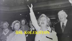BİRLEŞİK KRALLIK ESKİ BAŞBAKANI MARGARET THATCHER'IN ORİJİNAL FOTOĞRAFI - ORIGINAL PHOTOGRAPH OF FORMER UNITED KINGDOM PRIME MINISTER MARGARET THATCHER - 20 x 15 cm EBADINDA - DÜN MUHAFAZAKAR PARTİ'DE BÜYÜK BİR KARGAŞA YAŞANDI. ŞANS GETİREN SİYAH KEDİ MASKOTU, WESTMİNSTER'DAKİ CENTRAL HALL'DA DÜZENLENEN MUHAFAZAKAR KADINLAR KONFERANSI'NDAN AYRILIRKEN BİR DELEGE TARAFINDAN BAYAN MARGARET THATCHER'A TAKDİM EDİLDİ. SALON, SAĞCI KADINLARIN TERCİH ETTİĞİ TÜYLÜ, ÇİÇEKLİ ŞAPKALARLA DOLUYDU. BAYAN THATCHER, DÜNKÜ TOPLANTIDAN SONRA SİYAH KEDİ MASKOTUNU ELİNDE TUTUYOR. - İNGİLTERE SİYASET TARİHİ - (THIS WAS THE CAT AMONG THE PIGEONS OF THE CONSERVATIVE PARTY YESTERDAY. THE LUCKY BLACK CAT MASCOT WAS PRESENTED BY A DELEGATE TO MRS. MARGARET THATCHER AS SHE LEFT THE CONSERVATIVE WOMEN'S CONFERENCE AT CENTRAL HALL, WESTMINSTER. THE HALL WAS A SEA OF THOSE FEATHERY, FLOWERY HATS FAVOURED BY RIGHT-THINKING WOMEN. MRS THATCHER HOLDING UP THE BLACK CA MASCOT AFTER YESTERDAY MEETING.) - ÖZEL ARŞİV