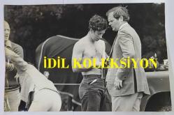 KRAL III. CHARLES'IN (CHARLES PHILIP ARTHUR GEORGE) ORİJİNAL FOTOĞRAFI - ORIGINAL PHOTOGRAPH OF CHARLES III, (CHARLES PHILIP ARTHUR GEORGE) - 25 x 17 cm EBADINDA - POLO PRENSİ!.. CHARLES, NUMARALI TAKIM KAZAĞINI ÇIKARIRKEN, YANINDAKİ BİR TRİBÜN MENAJERİ DE GÖZLERİNİ USTACA KAÇIRARAK, PRENSİN GÖĞSÜNÜN NADİR VE SON DERECE ETKİLEYİCİ BİR GÖRÜNTÜSÜNÜ SUNUYOR. - (POLO PRINCE!.. A RARE AND SINGULARLY IMPRESSIVE VIEW OF THE PRINCELY CHEST IS AFFORDED AS CHARLES CHANGES OUT OF HIS NUMBERED TEAM SWEATER WHILE AN SIDE STAND SIDE WITH EYES DISCREETLY AVERTED. CAMERA PRESS, LONDON, RICHARD SLADE) - ÖZEL ARŞİV