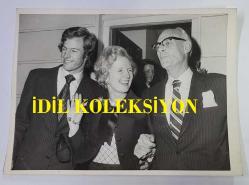 BİRLEŞİK KRALLIK ESKİ BAŞBAKANI MARGARET THATCHER'IN ORİJİNAL FOTOĞRAFI - ORIGINAL PHOTOGRAPH OF FORMER UNITED KINGDOM PRIME MINISTER MARGARET THATCHER - 20 x 15 cm EBADINDA - İNGİLTERE'NİN MUHALEFETTEKİ MUHAFAZAKAR PARTİSİ'NİN YENİ SEÇİLEN LİDERİ BAYAN MARGARET THATCHER, 11 ŞUBAT SALI AKŞAMI LONDRA'DA, DÖRT ERKEK RAKİBİNE KARŞI KAZANDIĞI ZAFERİ ONURLANDIRMAK İÇİN DÜZENLENEN RESEPSİYONA KATILMADAN ÖNCE EŞİ DENİS (SAĞDA) VE OĞLU MARK İLE EL SALLAYIP GÜLÜMSÜYOR. - İNGİLTERE SİYASET TARİHİ - (MRS MARGARET THATCHER, NEWLY ELECTED LEADER OF BRITAIN'S OPPOSITION CONSERVATIVE PARTY, SHARES A WAVE AND A SMILE WITH HER HUSBAND DENIS, RIGHT, AND SON MARK, IN LONDON, TUESDAY EVENING, FEBRUARY 11TH, BEFORE ATTENDING RECEPTION HONOURING HER VICTORY OVER FOUR MALE OPPONENTS. 1979) - ÖZEL ARŞİV