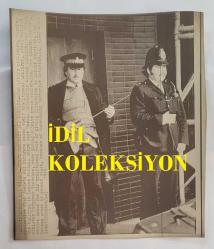 BİRLEŞİK KRALLIK ESKİ BAŞBAKANI MARGARET THATCHER'IN HABER AJANSI BASIM FOTOĞRAFI - NEWS AGENCY PHOTO OF FORMER UNITED KINGDOM PRIME MINISTER MARGARET THATCHER - 23 x 19 cm EBADINDA - 1979. GELENEKSEL ÜNİFORMALARININ ALTINDA KURŞUN GEÇİRMEZ YELEK VE TABANCA TAŞIYAN İKİ LONDRA POLİSİ, BATI ALMANYA ŞANSÖLYESİ HELMUT SCHMİDT VE BAŞBAKAN MARGARET THATCHER'IN ORTAK BASIN TOPLANTISI DÜZENLEDİĞİ LONDRA'DAKİ BİNANIN ÖNÜNDE DURUYOR. - İNGİLTERE SİYASİ TARİHİ - (TWO LONDON POLICEMAN, WEARING PROTECTIVE FLAK JACKETS AND HANDGUNS UNDER THEIR TRATIDIONAL UNIFORMS, STAND OUTSIDE THE BULDING IN LONDON FRIDAY, WHERE WEST GERMAN CHANCELLOR HELMUT SCHMIDT, AND PRIME MINISTER MARGARET THATCHER, WERE GIVING A JOINT PRESS CONFERENCE. 1979.)