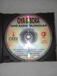 CD Oya Bora seni Bana yazmışlar albümü. Orijinal 1993 kırmızı bandrollü dönem baskı. Dinlemeyi etkilemeyen yoğun çizikler var baştan sona dinlendi sorunsuz çalışıyor