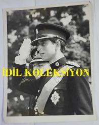 KRAL III. CHARLES'IN (CHARLES PHILIP ARTHUR GEORGE) ORİJİNAL FOTOĞRAFI - ORIGINAL PHOTOGRAPH OF CHARLES III, (CHARLES PHILIP ARTHUR GEORGE) - 20 x 15 cm EBADINDA - PRENS CHARLES, ASKERİ ÜNİFORMAYLA İLK KEZ HALK KARŞISINA ÇIKARAK, YENİ KRALİYET GALLER ALAYI'NIN ASKERLERİNİN TÖRENLE GEÇİŞİ SIRASINDA SELAM VERDİ. CARDİFF KALESİ'NDEKİ TÖRENDE, BAŞKOMUTAN OLAN PRENS, YENİ ALAY'A SANCAKLARINI TAKDİM ETTİ VE ONLAR ADINA CARDİFF ŞEHRİ FAHRİ VATANDAŞLIĞI UNVANINI KABUL ETTİ. - (PRINCE CHARLES - MAKING HIS FIRST PUBLIC APPEARANCE IN A MILITARY UNIFORM - TAKES THE SALUTE AS THE MEN OF THE NEW  ROYAL REGIMENT OF WALES MARCH PAST AT THE CEREMONIAL INAUGURATION OF THE REGIMENT. DURING THE CEREMONY AT CARDIFF CASTLE, THE PRINCE, WHO IS COLONEL-IN-CHIEF, PRESENTED THEIR COLOURS TO THE NEW REGIMENT AND ACCEPTED THE FREEDOM OF CARDIFF ON THEIR BEHALF. 12 JUNE 1969) - ÖZEL ARŞİV