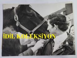 KRAL III. CHARLES'IN (CHARLES PHILIP ARTHUR GEORGE) ORİJİNAL 2'Lİ FOTOĞRAF SETİ - ORIGINAL (2) PHOTOGRAPH OF CHARLES III, (CHARLES PHILIP ARTHUR GEORGE) - 20 x 15 cm EBADINDA -MALL'UN SONUNDAKİ ÇEŞİTLİLİK SARAYININ SARAY SOYTARISI, TATİL HAFTASONU BOYUNCA YİNE İŞ BAŞINDAYDI. FOTOĞRAFTA GÖRÜLDÜĞÜ GİBİ: KRALİYET TARZINDA TAM İSABET: PRENS CHARLES, YÜZÜ YARIŞ PİSTİNDEN SIÇRAYAN ÇAMURLA KAPLI HALDE, ÇAMUR DENİZİNDE SAĞLAM ADIMLI ATI CANDLEWİCK'E ÖDÜLÜNÜ VERİYOR. - (THE COURT JESTER FROM THE PALACE OF VERIETIES AT THE END OF THE MALL WAS AT IT AGAIN DURING THE HOLIDAY WEEKEND. PHOTO SHOWS. ON THE NOSE ROYAL-STYLE: PRINCE CHARLES HIS FACE SPLATTERED BY DIRT FROM THE COURSE OFFERS HIS MOUNT, CANDLEWICK, A REWARD FOR SURE-FOOTEDNESS IN A SEA OF MUD.) - ÖZEL ARŞİV