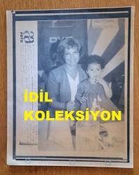 TÜRKİYE CUMHURİYETİ ESKİ BAŞBAKANI TANSU ÇİLLER'İN AJANS-BASIN FOTOĞRAFI (KAĞIT BASKI) - 21 x 17 cm EBADINDA - TANSU ÇİLLER, MASASINA GELEN BİR ÇOCUKLA POZ VERİRKEN