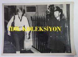 PRENSES DIANA'NIN ORİJİNAL FOTOĞRAFI - ORIGINAL PHOTOGRAPH OF PRINCESS DIANA - 20 x 15 cm EBADINDA - PRENS CHARLES'IN MÜSTAKBEL GELİNİ LADY DİANA, 25 ŞUBAT 1981 ÇARŞAMBA GÜNÜ BEKAR HAYATINA DAİR SON EŞYALARINI ALMAK İÇİN KISA BİR SÜRELİĞİNE LONDRA'DAKİ DAİRESİNE DÖNDÜĞÜNDE, KAÇINILMAZ GÜVENLİK AĞI DAHA DA SIKILAŞTI. LADY DİANA, SIKI GÜVENLİK ÖNLEMLERİ ALTINDA DAİRESİNDEN AYRILIYOR. - (THE INEVITABLE SECURITY NET TIGHTENED AROUND PRINCE CHARLES FUTURE BRIDE WHEN SHE BRIEFLY RETURNED TO HER LONDON FLAT TO PICK UP HER LAST BACHELOR-GIRL BELONGINGS ON WEDNESDAY 25TH. FEBRUARY 1981. LADY DIANA LEAVING HER FLAT AMID STRICT SECURITY.) - ÖZEL ARŞİV