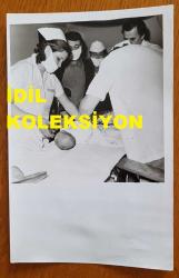 ÖMÜR GÖKSEL'İN ORİJİNAL FOTOĞRAFI - 18 x 12 cm EBADINDA - ÖMÜR GÖKSEL, 4 GÜNLÜK BEBEĞİNİ SÜNNET ETTİRİRKEN ÇEKİLMİŞ BİR KARE