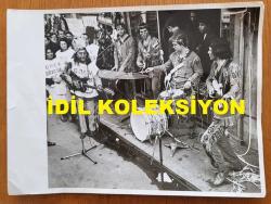 SELÇUK ALAGÖZ'ÜN ORİJİNAL BÜYÜK BOY FOTOĞRAFI - 24 x 18 cm EBADINDA - SELÇUK ALAGÖZ, ORKESTRASIYLA BİRLİKTE ANADOLU AJANSI GREVİNİ DESTEKLEMEK AMACIYLA MÜZİSYENLER SENDİKASI ADINA ANADOLU AJANSI BİNASI ÖNÜNDE MÜZİKLİ BİR GÖSTERİ YAPARKEN ÇEKİLMİŞ BİR KARE