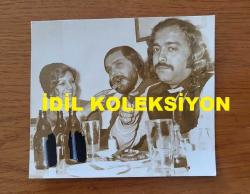 SELÇUK  ALAGÖZ & RANA ALAGÖZ'ÜN ORİJİNAL FOTOĞRAFI - 10 x 9 cm EBADINDA - SELÇUK ALAGÖZ, RANA ALAGÖZ ve TAYLAN KÖK, BİRLİKTE YEMEK YİYİP BİRA İÇERLERKEN ÇEKİLMİŞ BİR KARE. (ŞİŞELER SONRADAN MAVİ BOYA İLE BOYANMIŞ)