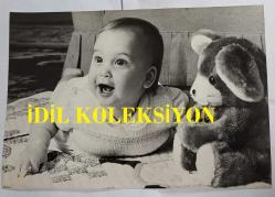 KRAL III. CHARLES (CHARLES PHILIP ARTHUR GEORGE) ve PRENSES DIANA'NIN OĞLU PRENS WILLIAM'IN ORİJİNAL BÜYÜK BOY FOTOĞRAFI - ORIGINAL PHOTOGRAPH OF PRINCE WILLIAM - 25 x 20 cm EBADINDA - YEDİ AYLIK PRENS WİLLİAM, KENSİNGTON SARAYI'NDA EN SEVDİĞİ OYUNCAĞI OLAN YUMUŞAK BİR KOALA AYISININ YANINDA TEK BAŞINA FOTOĞRAF ÇEKTİRİLİRKEN ANNE VE BABASINA GÜLÜMSÜYOR. SAĞLAM VE GÜÇLÜ YAPISIYLA DİKKAT ÇEKEN PRENS WİLLİAM, FOTOĞRAF ÇEKİMİ BOYUNCA NEŞELİYDİ. - (SEVEN MONTHS OLD, PRINCE WILLIAM SMILES AT HIS PARENTS AS HE IS PHOTOGRAPHED BY HIMSELF AT KENSINGTON PALACE NEXT TO HIS FAVOURITE TOY, A SOFT KOALA BEAR. HE IS ROBUST, AND STURDY, AND WAS GOOD-HUMOURED THROUGHOUT THE PHOTOGRAPHIC SESSION.. TIM GRAHAM) - ÖZEL ARŞİV