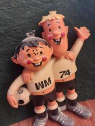 1974 FIFA Dünya Kupası'nın resmi maskotları olan Tip ve Tap 13 x 11 cm. Tarih: 1974 yılında Batı Almanya'da düzenlenen Dünya Kupası için tasarlanmıştır.  Detaylar: Maskotlar, Batı ve Doğu Almanya'yı temsil eden iki kardeştir.  Sembolizm: Üzerlerindeki 