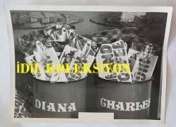 PRENSES DIANA'NIN ORİJİNAL FOTOĞRAFI - ORIGINAL PHOTOGRAPH OF PRINCESS DIANA - 20 x 15 cm EBADINDA - GALLER PRENSİ VE PRENSESİNE DÜĞÜNLERİ VESİLESİYLE VERİLEN HEDİYELER, 5 AĞUSTOS ÇARŞAMBA GÜNÜ ST JAMES SARAYI'NDA SERGİLENDİ. NE KADAR TATLI... ONA VE ONA ÖZEL KARAMELLER. - PRESENTS GIVEN TO THE PRINCE AND PRINCESS OF WALES ON THE OCCASION OF THEIR WEDDING WENT ON SHOW IN ST JAMES'S PALACE ON WEDNESDAY AUGUST 5. HOW SWEET... HIS AND HERS TOFFESS.