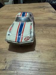 Vintage Teneke Corvette Yarış Arabası – PİLLİ 1960–70’ler dönemi, teneke gövdeli Pilli **Chevrolet Corvette yarış arabası oyuncak. Üzerinde “Corvette Racing Team” yazıları ve yarış çizgileri bulunmaktadır. Orijinal boyası üzerinde, yaşına bağlı kullanım ve pas izleri vardır. Motoru arızalı olduğu için söküldü arka taraftaki ışığı yanıyor. Koleksiyonluk dekoratif bir parçadır.