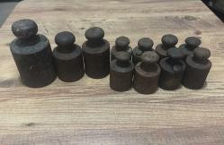 Mühürlü & Damgalı Antika Terazi Ağırlık Seti  1 adet 2 kiloluk  2 adet 1 kiloluk 8 adet 500 gramlık Toplam  11  adet Koleksiyonluk ve dekoratif değeri yüksek, mühür detayları korunmuş tam set! Her parça üzerinde belirgin harf damgaları ve çerçeveli dönem mühürleri mevcuttur.